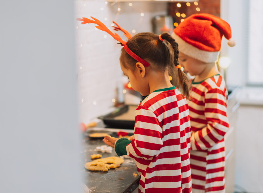 Children in Christmas costume pull out forms from the dough