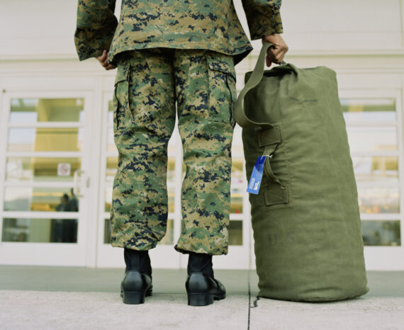 Military soldier with bag in airport, low section