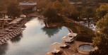 Beautifully designed poolside area at La Cantera Resort with comfortable lounge chairs, umbrellas, and lush greenery.