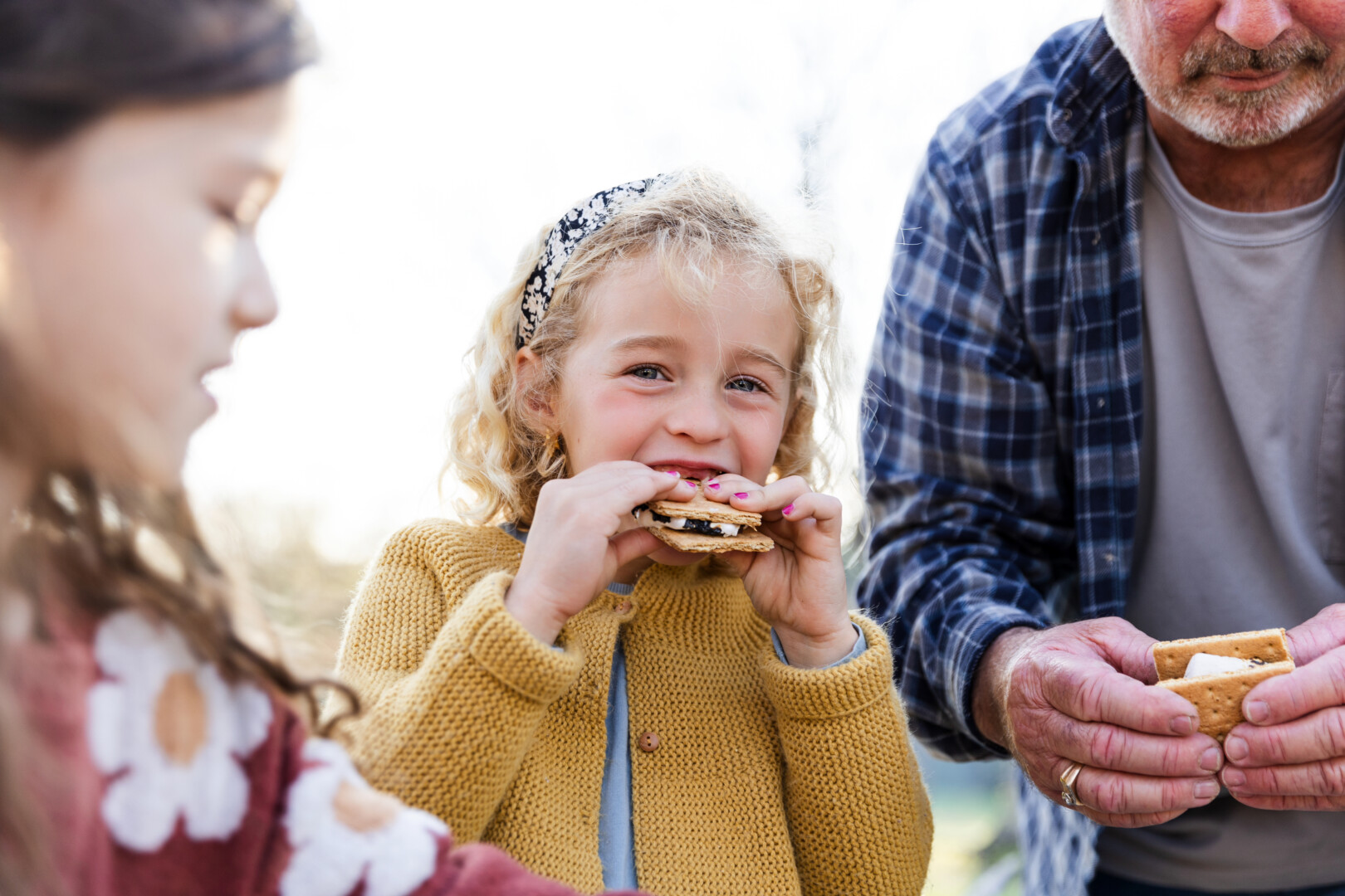 Young girl looks at the camera while enjoying a smore