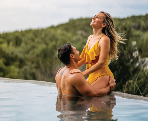 Couple on edge of infinity pool at Loma de Vida