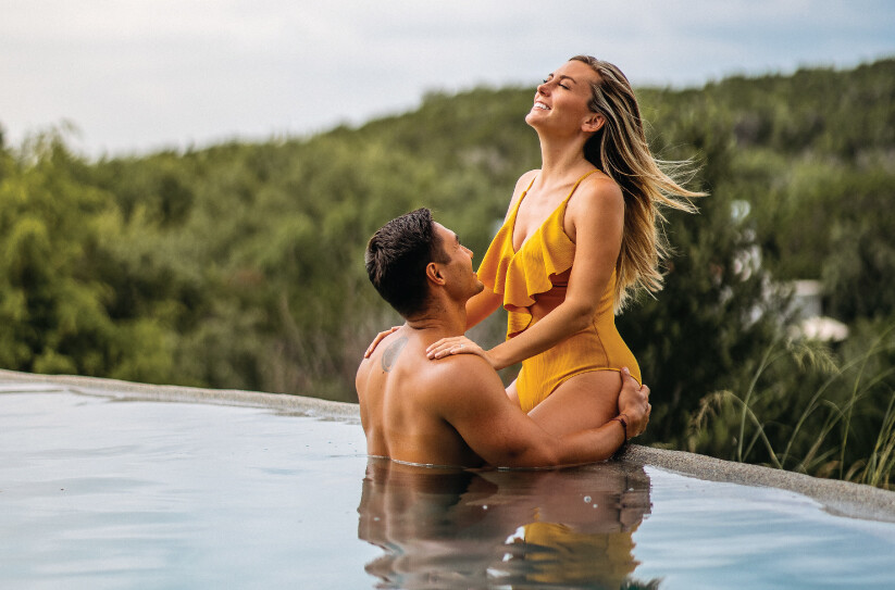 Couple on edge of infinity pool at Loma de Vida