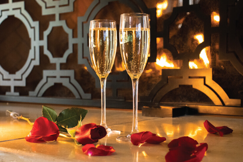 Two Glasses of Bubbles by the Fire With Roses