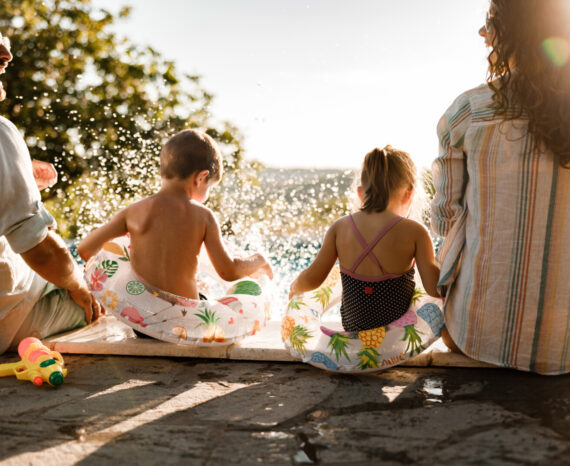 Happy family having fun by the pool in summer day.